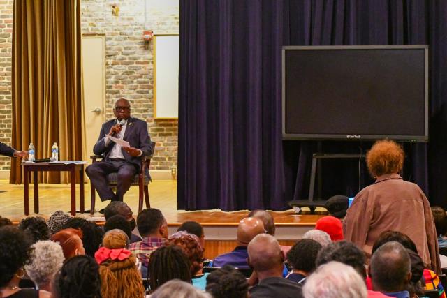 Congressman Clyburn addressing a women in the audience asking a question.